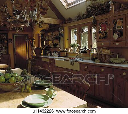 Green plates and cups on pine table in country kitchen with fitted pine cupboards and white ceramic sink View Large Photo Image Stock Photograph - Green plates and cups on pine table in country kitchen with fitted pine cupboards and white ceramic sink. Fotosearch