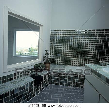 Green tiled walls and floor in modern white bathroom with tiled raised seating View Large Photo Image Stock Photograph - Green tiled walls and floor in modern white bathroom with tiled raised seating. Fotosearch