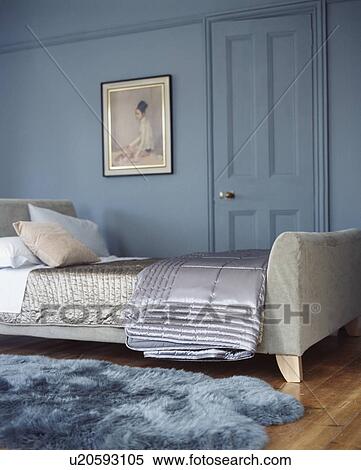 Grey silk quilts on grey upholstered bed in modern blue bedroom with blue faux fur rug on wooden floor View Large Photo Image Stock Photography - Grey silk quilts on grey upholstered bed in modern blue bedroom with blue faux fur rug on wooden floor. Fotosearch