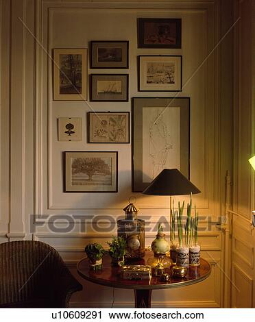 Group of pictures on wall above lighted lamp on table View Large Photo Image Stock Image - Group of pictures on wall above lighted lamp on table. Fotosearch