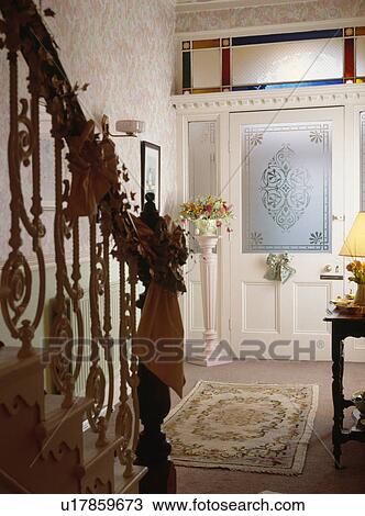 Hall with engraved glass panel in front door and ornate bannisters decorated for Christmas View Large Photo Image Stock Image - Hall with engraved glass panel in front door and ornate bannisters decorated for Christmas . Fotosearch