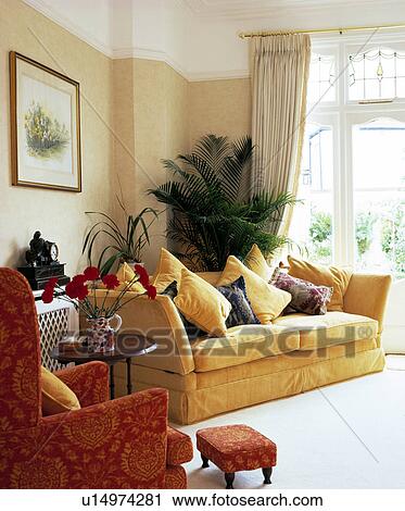 Stock Image - Houseplants in traditional living room with yellow sofa. Fotosearch