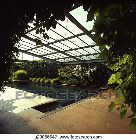 Indoor swimming pool with terracotta tiled floor and glass roof View Large Photo Image Stock Photo - Indoor swimming pool with terracotta tiled floor and glass roof. Fotosearch