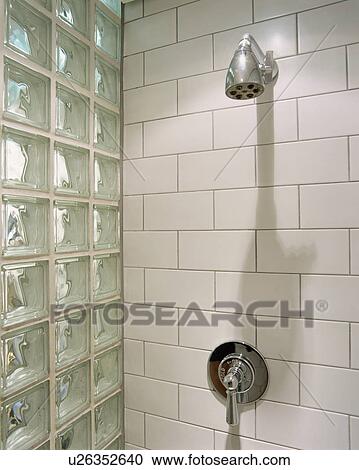 Stock Image - Inside a tiled shower with glass brick wall. Fotosearch