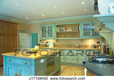 Island unit with wood worktop in pastel turquoise kitchen with distressed paint effect fitted cupboards and recessed lighting View Large Photo Image Stock Image - Island unit with wood worktop in pastel turquoise kitchen with distressed paint effect fitted cupboards and recessed lighting. Fotosearch