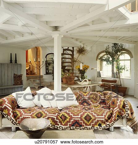 Kelim rug on sofa in living room in converted watermill View Large Photo Image Stock Photo - Kelim rug on sofa in living room in converted watermill. Fotosearch
