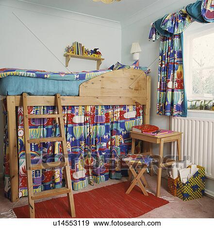 Ladder to pine platform bed with colourful curtain hiding storage and matching curtain at the window View Large Photo Image Stock Photo - Ladder to pine platform bed with colourful curtain hiding storage and matching curtain at the window. Fotosearch