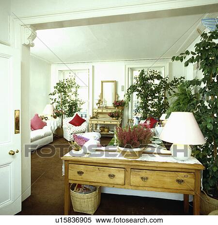 Lamp on small pine table in traditional living room View Large Photo Image Stock Photography - Lamp on small pine table in traditional living room. Fotosearch