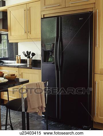 Large black American style fridge freezer in modern fitted kitchen with pale wooden fitted cupbaords View Large Photo Image Stock Photography - Large black American style fridge freezer in modern fitted kitchen with pale wooden fitted cupbaords. Fotosearch