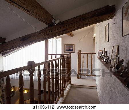 Large ceiling beams above white cottage landing with carved wooden bannisters View Large Photo Image Stock Image - Large ceiling beams above white cottage landing with carved wooden bannisters. Fotosearch