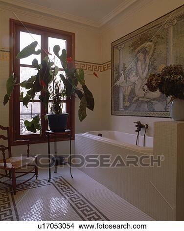 Large houseplant on table in front of window in bathroom with black+white tiled floor and mosaic picture above bath View Large Photo Image Picture - Large houseplant on table in front of window in bathroom with black+white tiled floor and mosaic picture above bath . Fotosearch