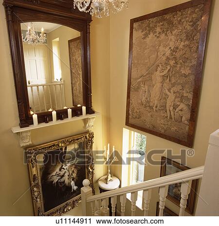 Large mahogany mirror above shelf with candles on landing wall with tapestry and pictures View Large Photo Image Stock Image - Large mahogany mirror above shelf with candles on landing wall with tapestry and pictures. Fotosearch