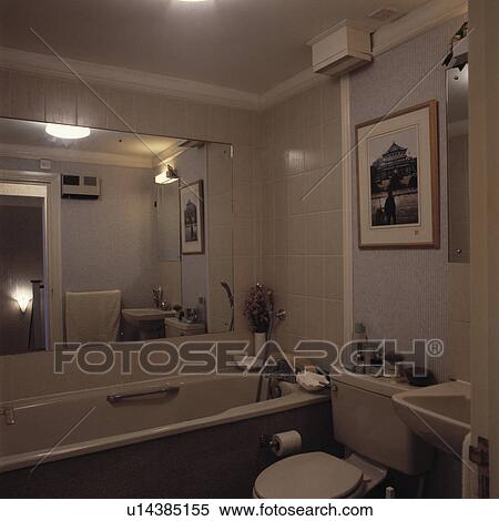 Large mirror above bath in small bathroom with beige bath and toilet View Large Photo Image Stock Photography - Large mirror above bath in small bathroom with beige bath and toilet. Fotosearch