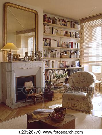 Stock Image - Large mirror above fireplace in traditional living room. Fotosearch