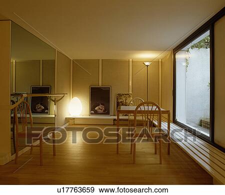 Large mirror and long slatted bench below window in minimal dining room with wooden flooring View Large Photo Image Stock Photo - Large mirror and long slatted bench below window in minimal dining room with wooden flooring. Fotosearch