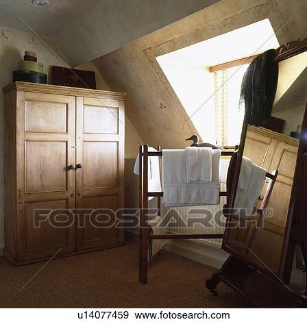 Large Old Pine Wardrobe In Attic Bedroom With Linen On Wooden