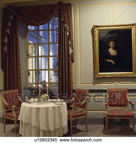 Large picture on grey panelled wall beside tall window in dining room with white cloth on small white table View Large Photo Image Stock Photography - Large picture on grey panelled wall beside tall window in dining room with white cloth on small white table. Fotosearch