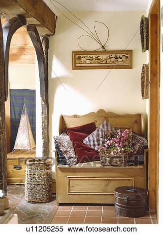 Large willow basket beside old pine settle piled with cushions in corner of country hall View Large Photo Image Stock Photography - Large willow basket beside old pine settle piled with cushions in corner of country hall. Fotosearch