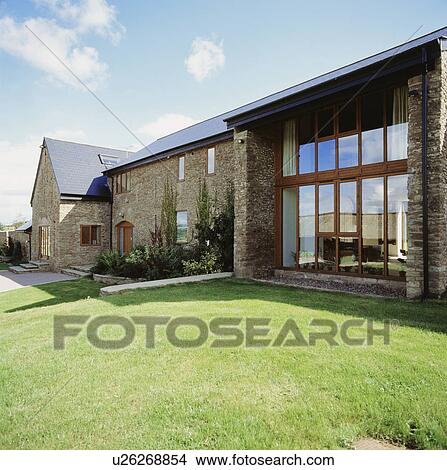 Lawn in front of large windows on modern extension to traditional barn conversion View Large Photo Image Picture - Lawn in front of large windows on modern extension to traditional barn conversion. Fotosearch