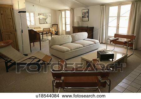 Le Corbusier chaiselongue and Marcel Breuer Wassily chairs with cream sofa in neutral living and dining room View Large Photo Image Picture - Le Corbusier chaiselongue and Marcel Breuer Wassily chairs with cream sofa in neutral living and dining room . Fotosearch