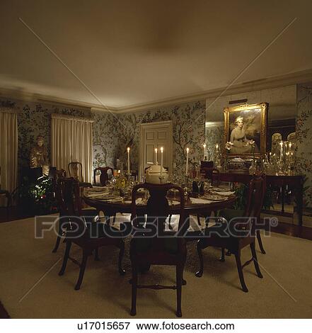 Stock Photo - Lighted candles and place settings on antique table with matching chairs in formal dining room. Fotosearch