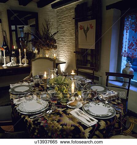 Lighted candles and place settings on table in cottage dining room View Large Photo Image Stock Photography - Lighted candles and place settings on table in cottage dining room . Fotosearch