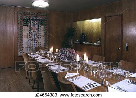 Lighted candles and white placemats on rectangular table in panelled dining room View Large Photo Image Stock Image - Lighted candles and white placemats on rectangular table in panelled dining room. Fotosearch
