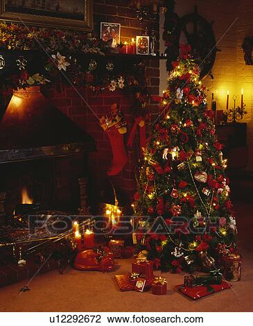 Stock Image - Lighted Christmas tree in cottage living room. Fotosearch