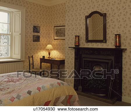 Lighted lamp on desk in corner of bedroom with fireplace and floral patterned wallpaper View Large Photo Image Stock Image - Lighted lamp on desk in corner of bedroom with fireplace and floral patterned wallpaper. Fotosearch