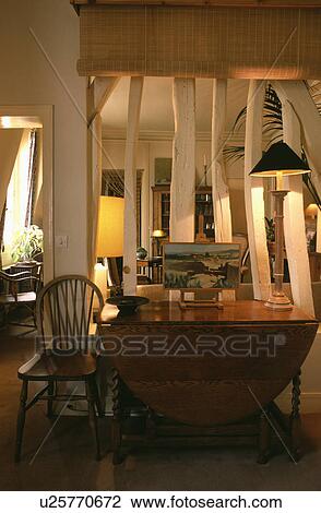 Lighted lamp on table in front of wall with white exposed beams below split-cane blind View Large Photo Image Stock Image - Lighted lamp on table in front of wall with white exposed beams below split-cane blind. Fotosearch
