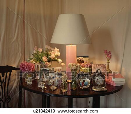 Lighted lamp on table with collection of photographs View Large Photo Image Stock Photo - Lighted lamp on table with collection of photographs. Fotosearch