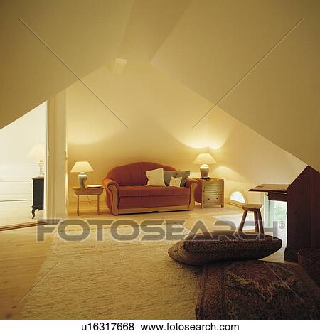 Lighted lamps and red sofa in uncluttered white loft conversion living room View Large Photo Image Stock Photo - Lighted lamps and red sofa in uncluttered white loft conversion living room. Fotosearch