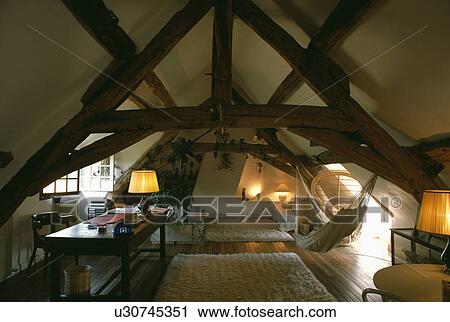 Lighted lamps in beamed attic living room View Large Photo Image Stock Image - Lighted lamps in beamed attic living room. Fotosearch
