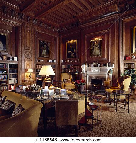 Stock Photograph - Lighted lamps in panelled country drawing room. Fotosearch