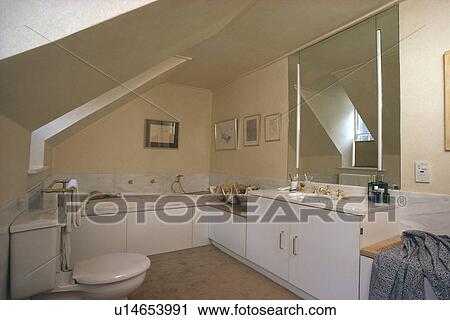 Lighted mirror above basin in vanity unit in attic bathroom View Large Photo Image Stock Image - Lighted mirror above basin in vanity unit in attic bathroom. Fotosearch
