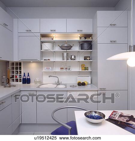 Lighting above shelving in modern grey kitchen with hidden fridge freezer View Large Photo Image Stock Photography - Lighting above shelving in modern grey kitchen with hidden fridge freezer. Fotosearch