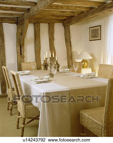Linen runner on white cloth in beamed cottage dining room with wicker chairs View Large Photo Image Stock Image - Linen runner on white cloth in beamed cottage dining room with wicker chairs. Fotosearch