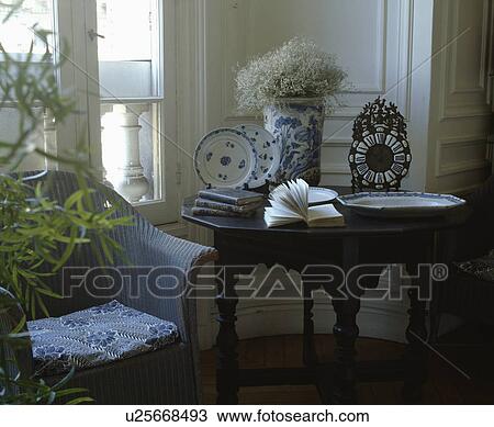 Lloyd Loom armchair beside antique table with blue+white china in traditional living room View Large Photo Image Stock Image - Lloyd Loom armchair beside antique table with blue+white china in traditional living room. Fotosearch