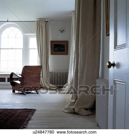 Long cream curtains in uncluttered living room with wooden floor View Large Photo Image Stock Image - Long cream curtains in uncluttered living room with wooden floor. Fotosearch