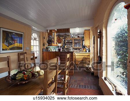 Long wooden table and chairs in kitchen dining room with painted white wooden ceiling View Large Photo Image Stock Photography - Long wooden table and chairs in kitchen dining room with painted white wooden ceiling. Fotosearch