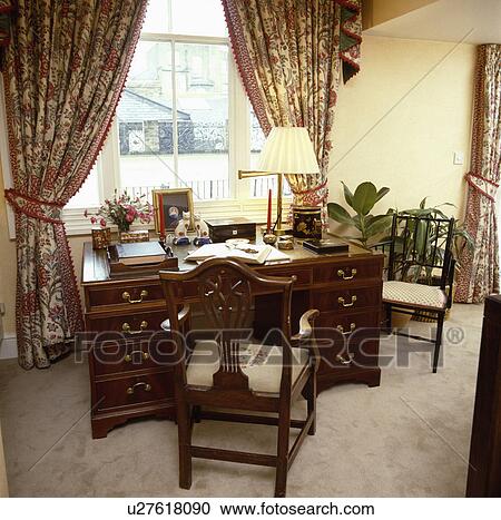 Mahogany desk and chair in traditional study with patterned curtains View Large Photo Image Stock Image - Mahogany desk and chair in traditional study with patterned curtains. Fotosearch