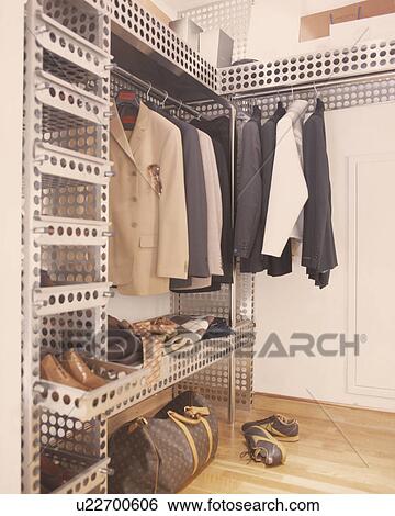 Stock Photograph - Men's jackets and shoes on hi-tech stainless steel shelf unit. Fotosearch
