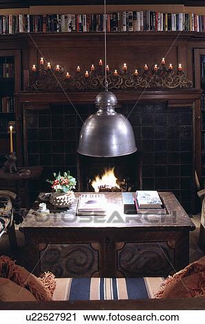 Stock Image - Metal pendant lamp above wooden table. Fotosearch