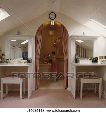 Mirrors Above Vanity Units And Stools On Either Side Of Arched