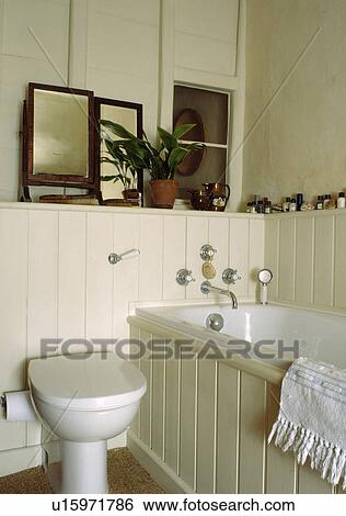Mirrors On Shelf In Cream Panelled Cottage Bathroom Stock Cream Panelled Cottage Bathroom