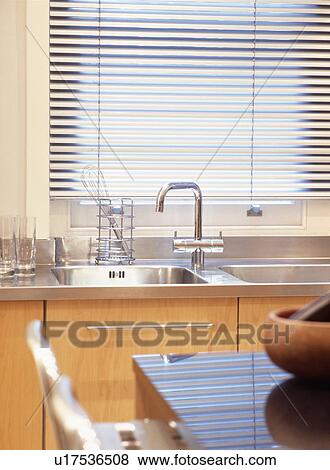 Mixer tap and double stainless steel sink below window with slatted blind in modern kitchen View Large Photo Image Stock Photo - Mixer tap and double stainless steel sink below window with slatted blind in modern kitchen. Fotosearch