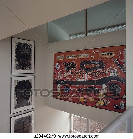 Stock Photo - Modern abstract picture and group of three black+white prints on wall above modern landing. Fotosearch