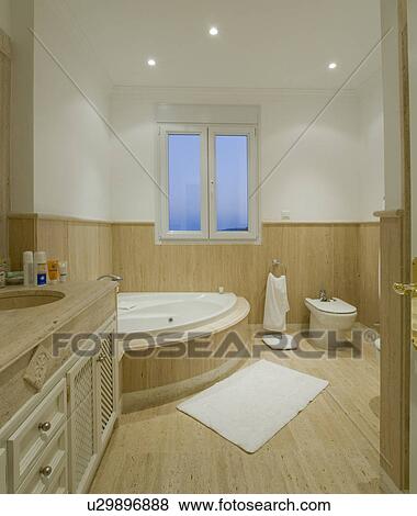 Modern bathroom with corner bathtub and half-panelling on walls View Large Photo Image Stock Photo - Modern bathroom with corner bathtub and half-panelling on walls. Fotosearch