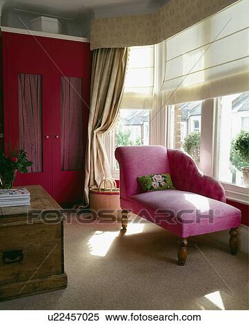Modern pink chaise longue infront of bay window with roman blinds and pelmet topped curtains View Large Photo Image Stock Photography - Modern pink chaise longue infront of bay window with roman blinds and pelmet topped curtains. Fotosearch