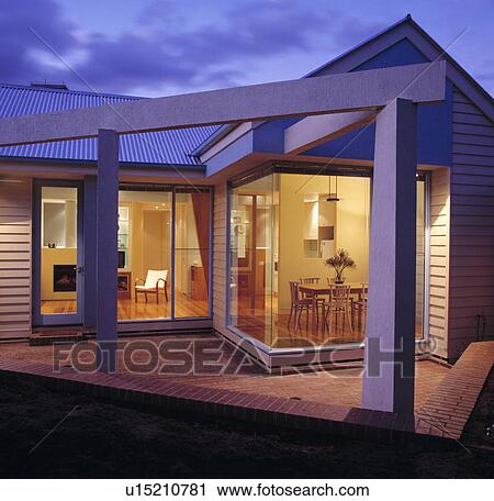 Modern single-storey town house lit at night View Large Photo Image Stock Image - Modern single-storey town house lit at night. Fotosearch